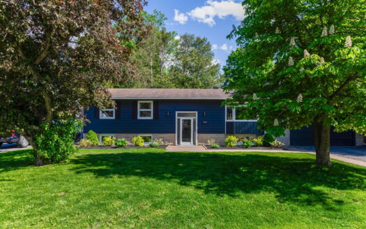 Front view of updated family home with interlock driveway and landscaped yard at 102 Coburn Avenue in Ottawa